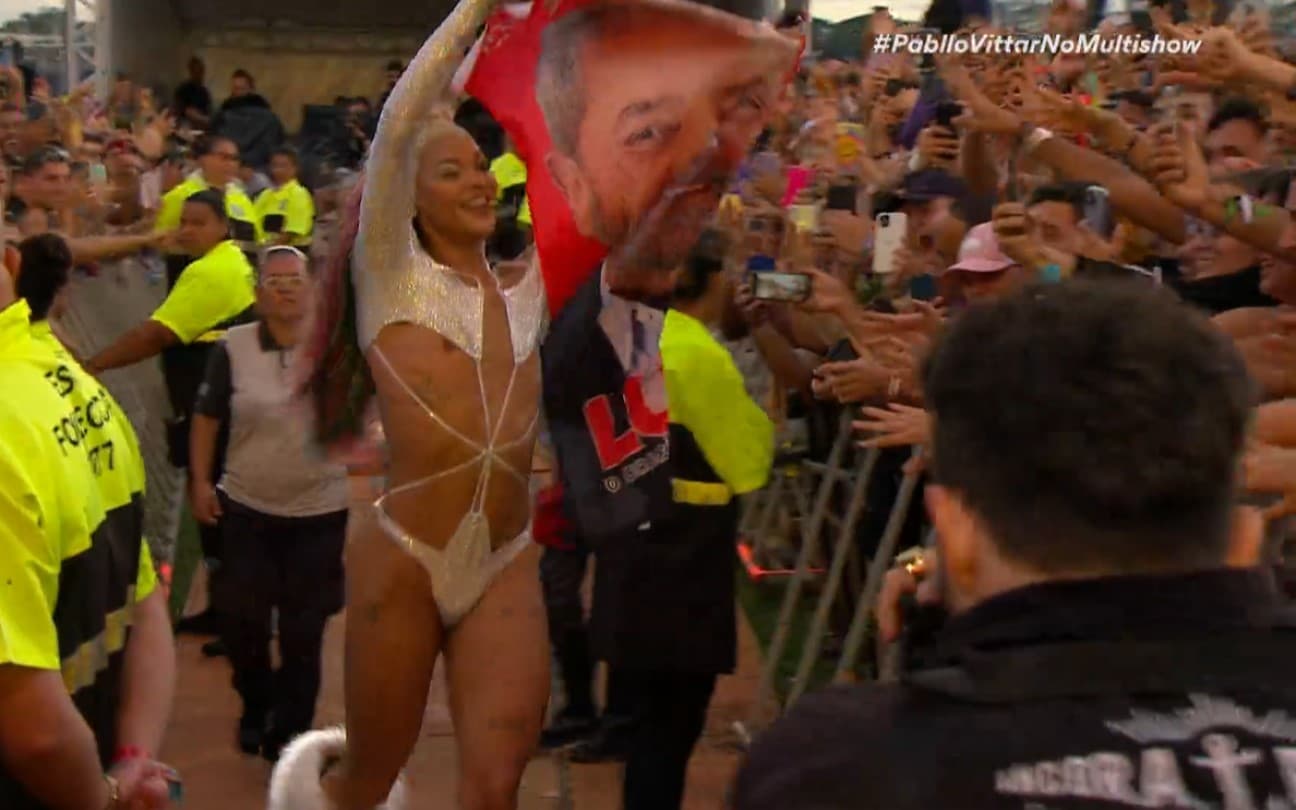 25.mar.2022 - Pabllo Vittar carrega uma bandeira com o rosto do ex-presidente Lula no primeiro dia de Lollapalooza Brasil 2022