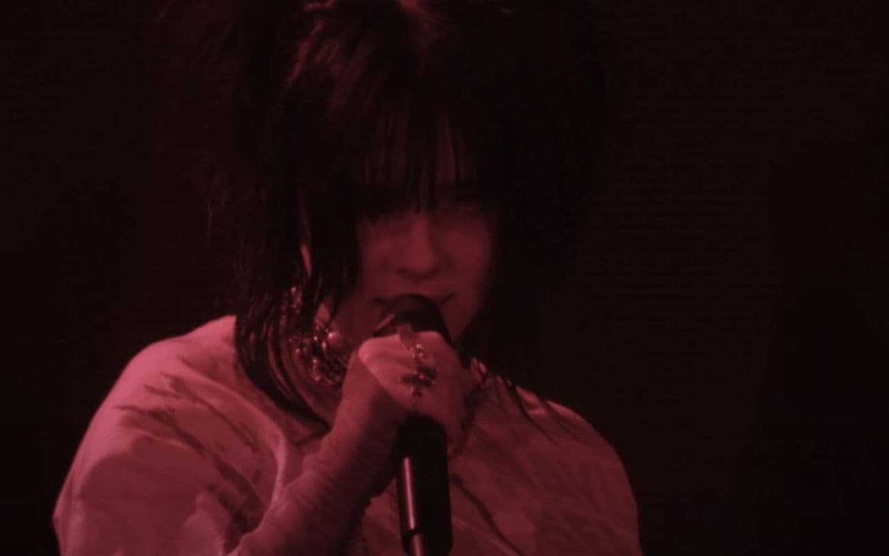 Billie Eilish canta com um microfone na mão