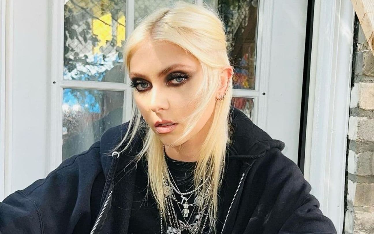 Taylor Momsen olha para a câmera, sentada em varanda