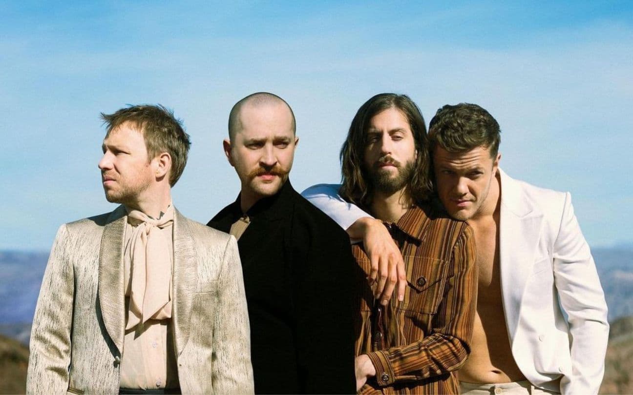 A banda Imagine Dragons posa para foto em frente a um deserto