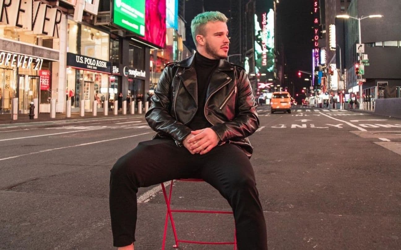 Matheus Fernandes sentado em cadeira na Times Square, em Nova York