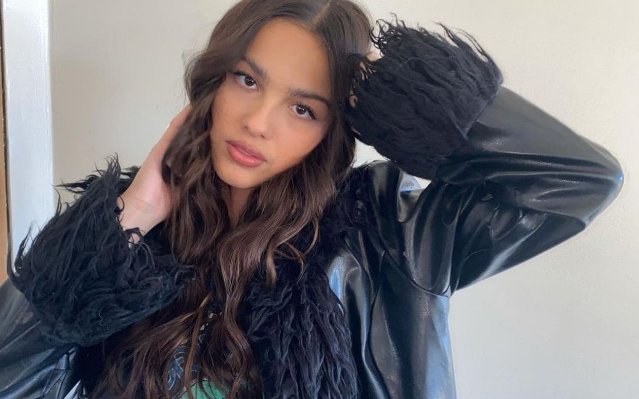 Olivia Rodrigo posa para foto com as mãos na cabeça