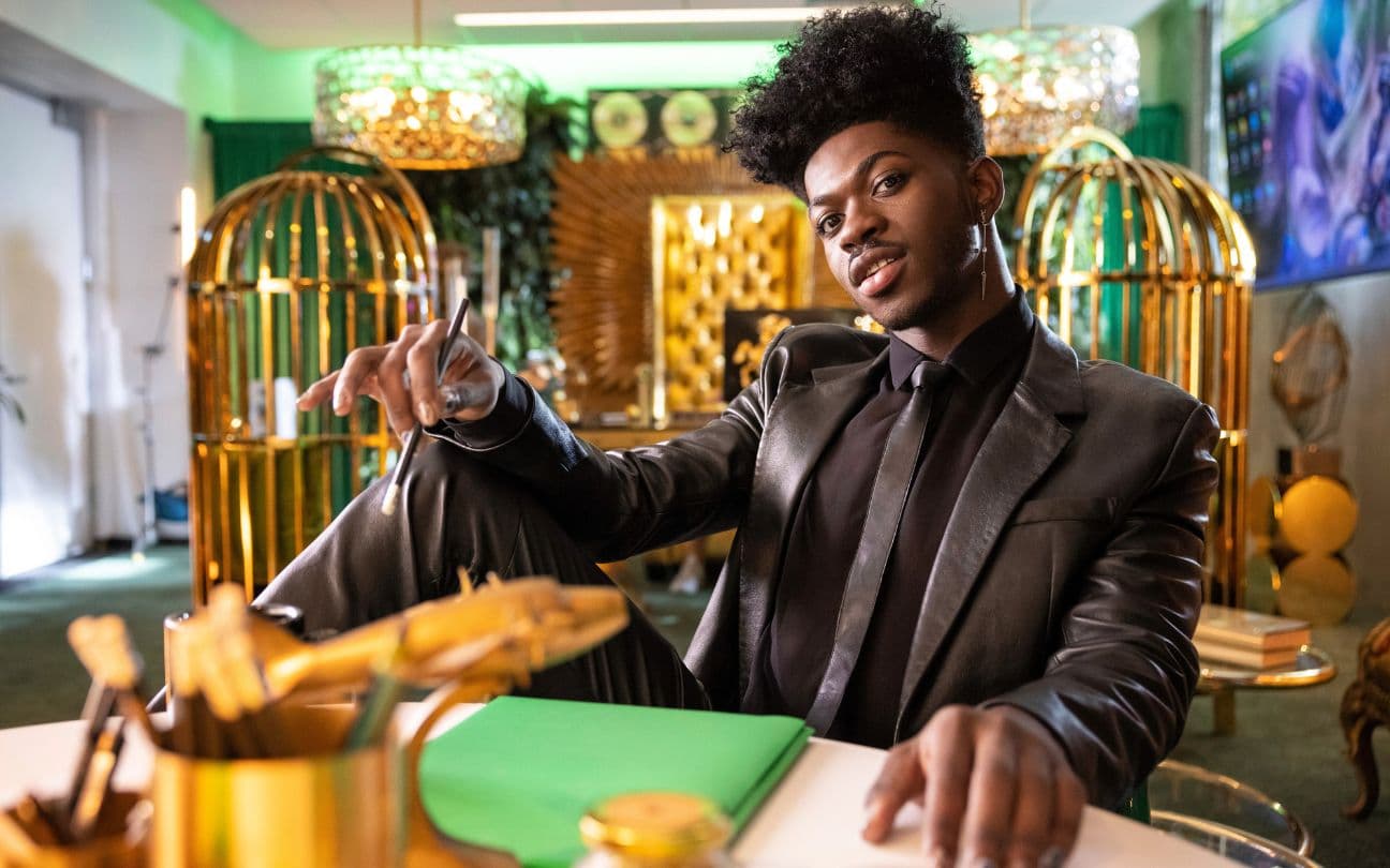 Lil Nas X posa sentado em uma cadeira
