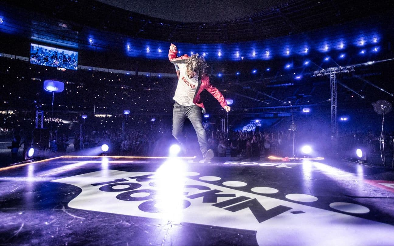 Homem pulando no palco do Rockin' 1000