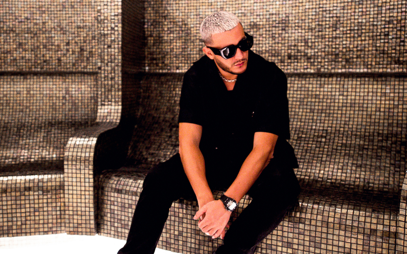 DJ Snake sentado em um banco preto