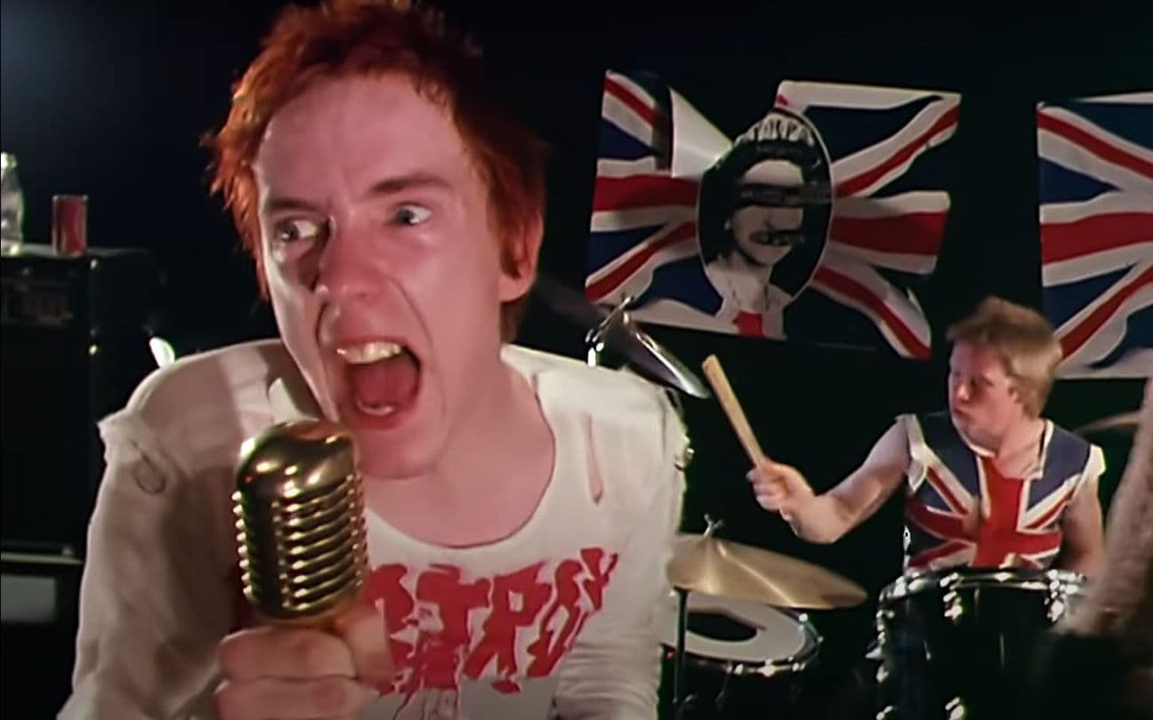 John Lydon canta cem frente ao microfone no clipe dos Sex Pistols
