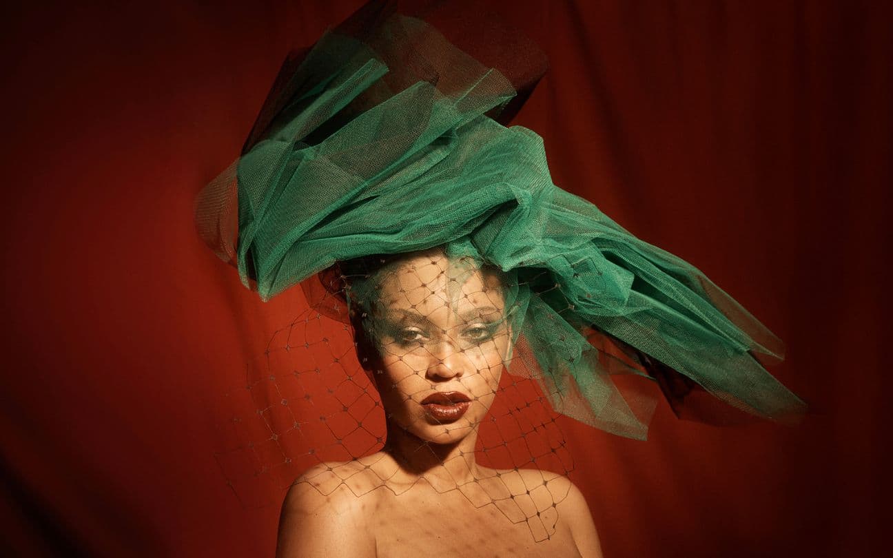 Beyoncé usando chapéu verde em um estúdio vermelho