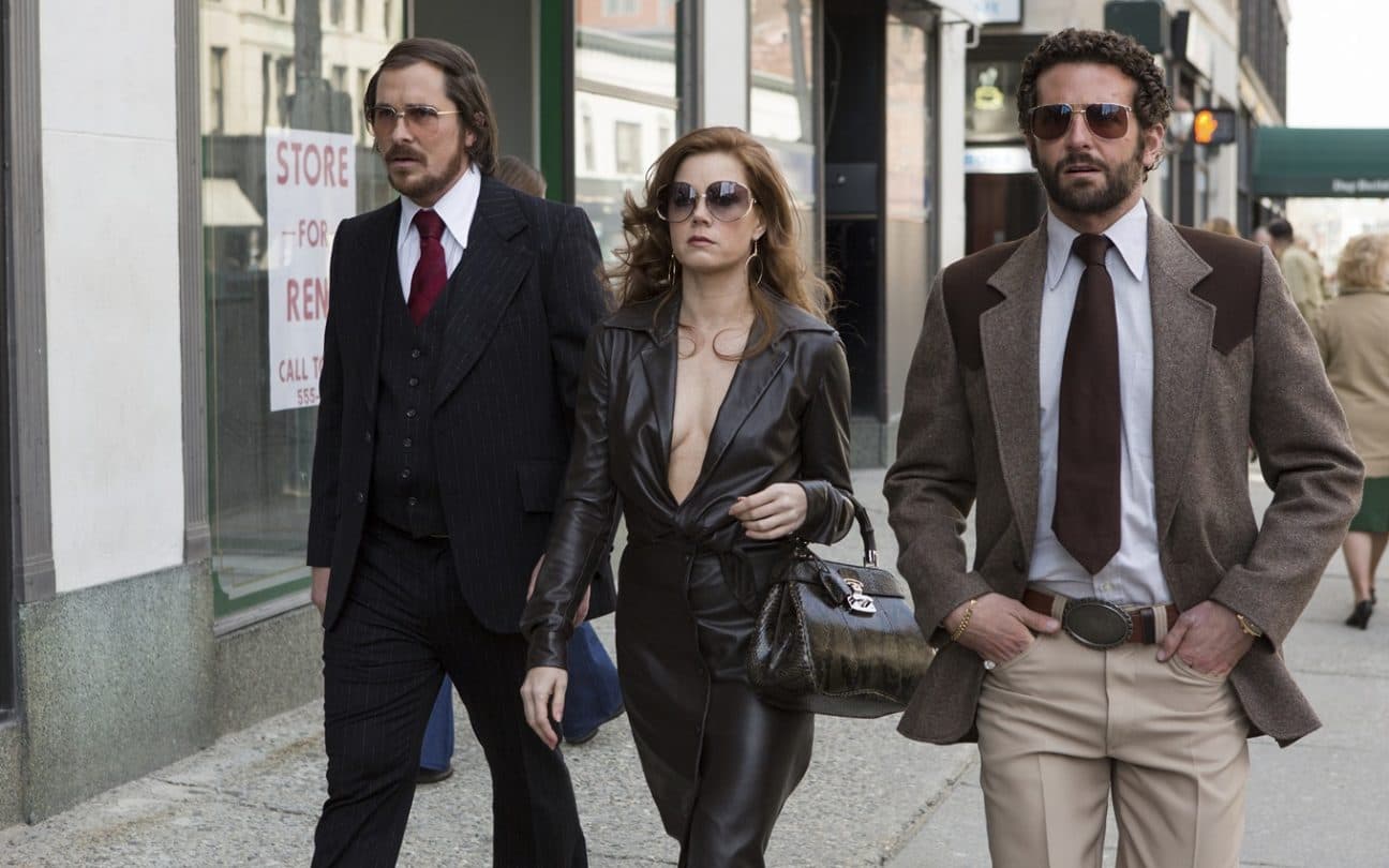 Christian Bale, Amy Adams e Bradley Cooper em cena de Trapaça