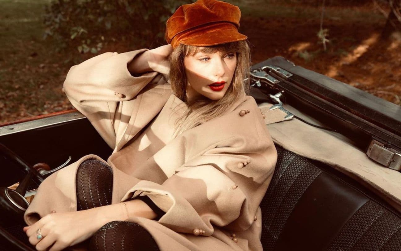 Taylor Swift sentada em carro nas fotos de Red (Taylor's Versions)